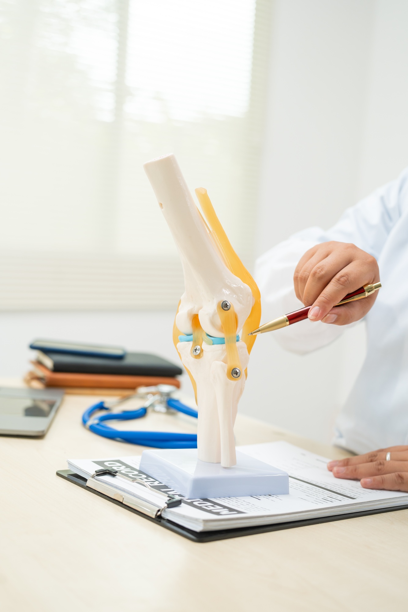 a female doctor works at desk in the hospital discussing bone joint diseases like osteoarthritis 1 1